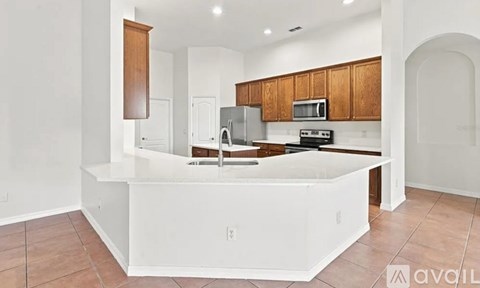 A kitchen with white countertops and wooden cabinets.