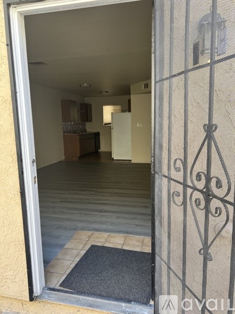 A view into a hallway through a door with a metal grate.
