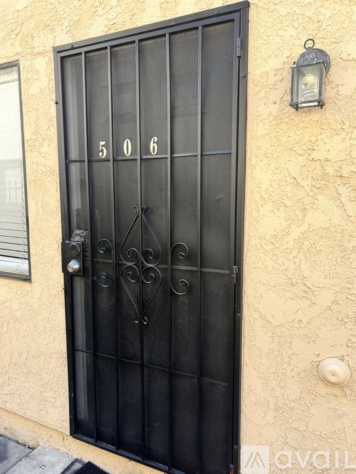 A black wrought iron door with the numbers 506 on it.