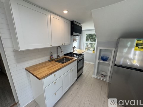 A kitchen with white cabinets and a wooden countertop.