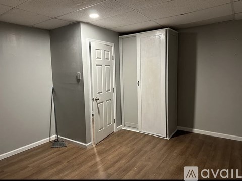 A room with a broom and a white door.