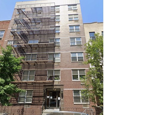 A tall brick building with a fire escape on the side.