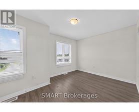 A room with a window and a wooden floor.