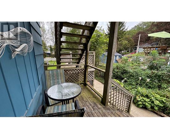 A wooden deck with a table and chairs and a whale design on the wall.