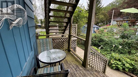 A wooden deck with a table and chairs and a whale design on the wall.