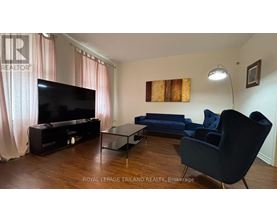 A living room with a television, sofa, and chair.
