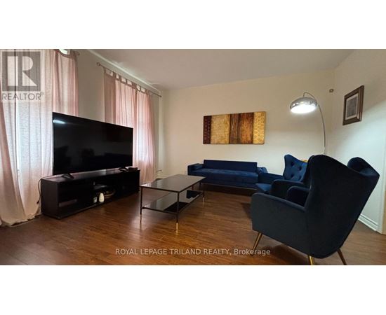 A living room with a television, sofa, and chair.