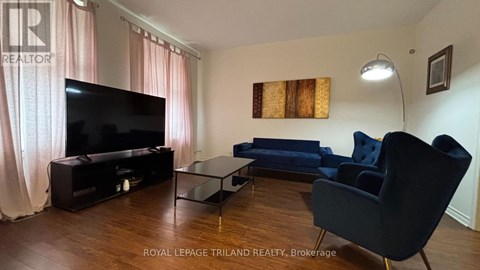 A living room with a television, sofa, and chair.
