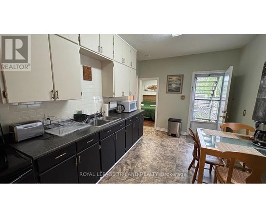 A kitchen with black cabinets and a sink.