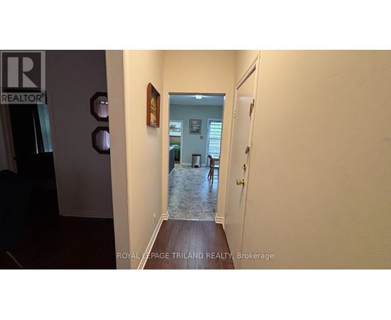 A hallway with a door on the right and a wall on the left.