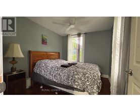 A bedroom with a bed, nightstand, and lamp.