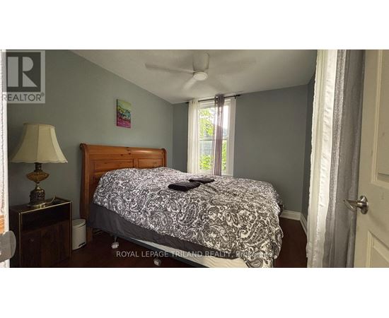 A bedroom with a bed, nightstand, and lamp.