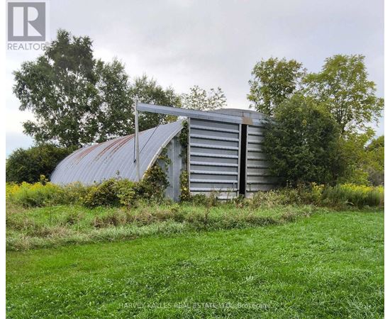 A dilapidated building sits in a grassy field.