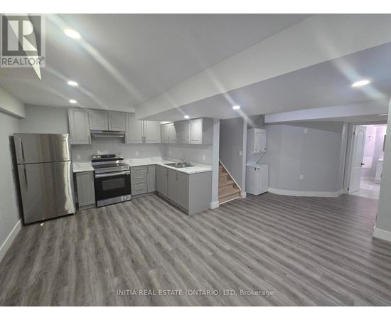 A kitchen with a refrigerator, oven, and microwave.