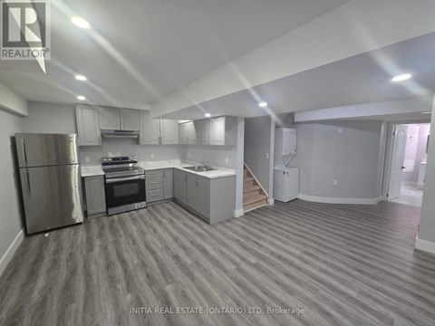 A kitchen with a refrigerator, oven, and microwave.