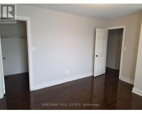 A room with a white door and a white wall with a Kingsway Real Estate sign.