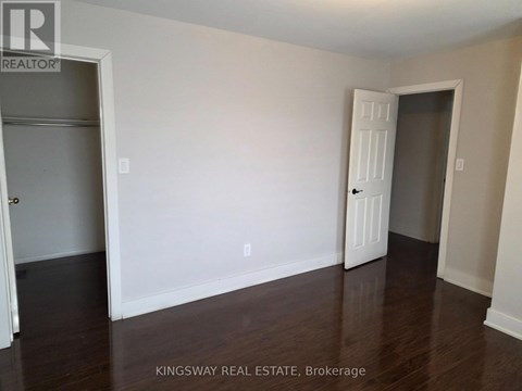 A room with a white door and a white wall with a Kingsway Real Estate sign.