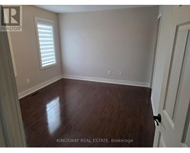 A room with wooden flooring and a white door.