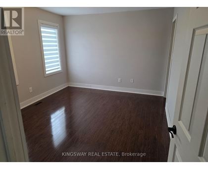 A room with wooden flooring and a white door.