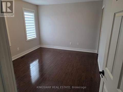 A room with wooden flooring and a white door.