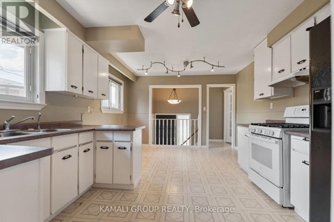 A kitchen with white cabinets and a tiled floor.