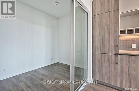A room with a glass door and wooden cabinets.
