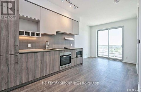 A kitchen with wooden cabinets and a microwave built into the counter.