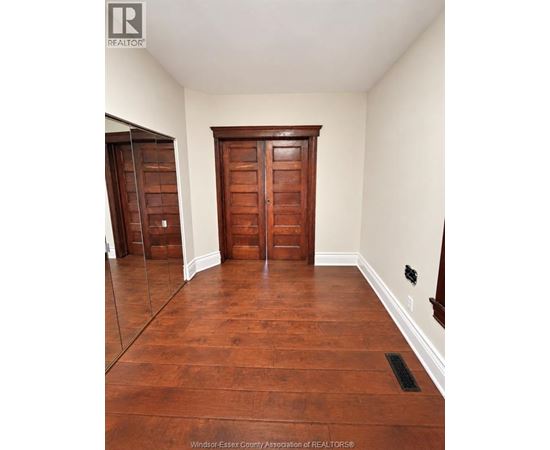 A room with wooden floors and a wooden door.
