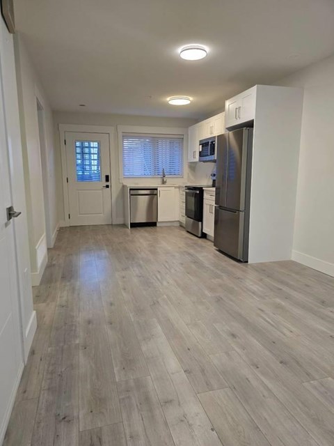 A kitchen with a refrigerator, microwave, and oven.