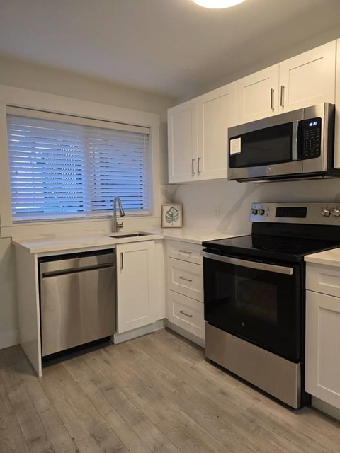 A kitchen with a black microwave above a stove.