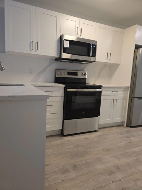 A kitchen with a stove top oven and microwave above it.