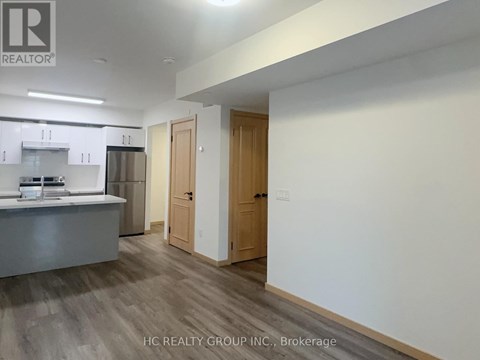A kitchen area with a refrigerator, microwave, and oven.