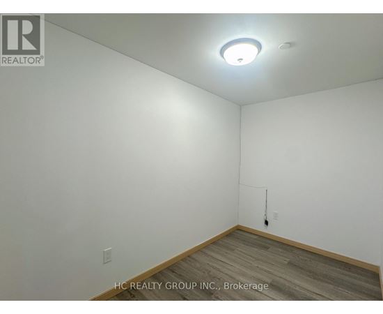 A room with a white wall and a wooden floor.