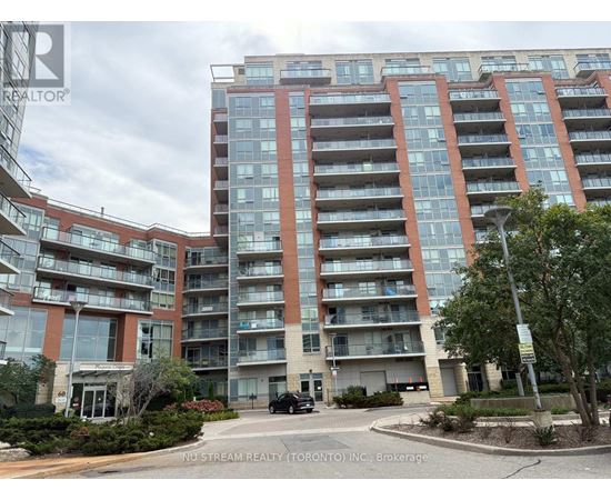 A large apartment building with a car parked in front.