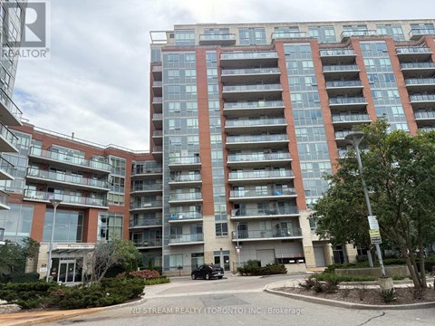 A large apartment building with a car parked in front.