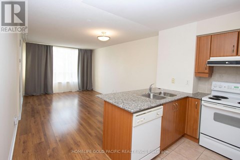 A kitchen with wooden cabinets and a granite countertop.