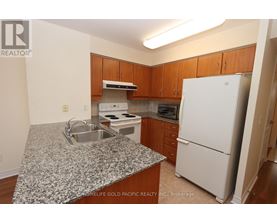 A kitchen with granite countertops and wooden cabinets.