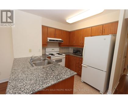 A kitchen with granite countertops and wooden cabinets.