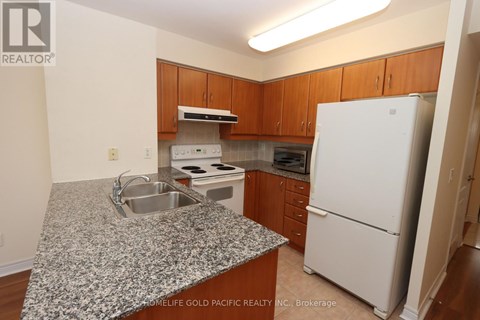 A kitchen with granite countertops and wooden cabinets.