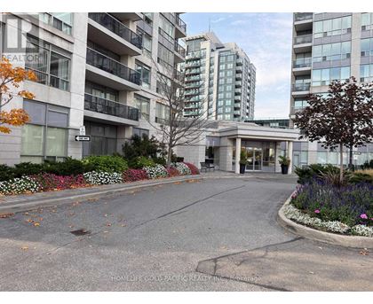 A street view of a residential area with apartment buildings and a realtor sign.