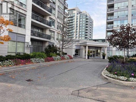 A street view of a residential area with apartment buildings and a realtor sign.
