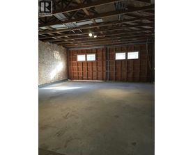A room under construction with wooden panels on the walls and a concrete floor.