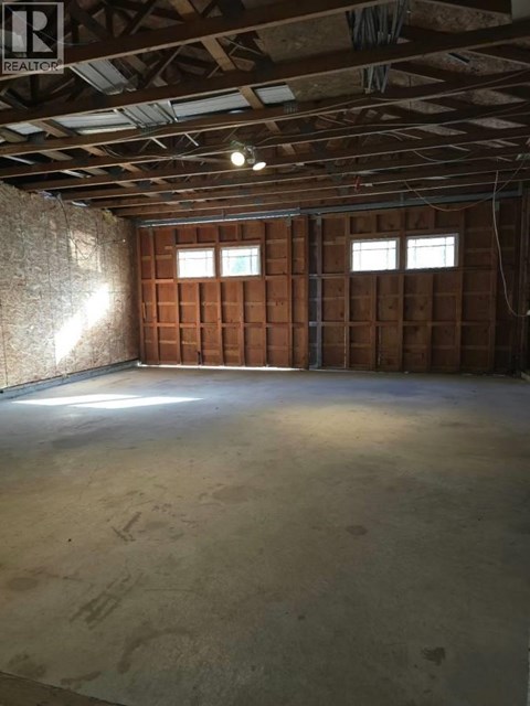 A room under construction with wooden panels on the walls and a concrete floor.