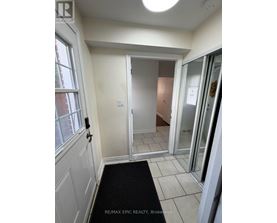 A hallway with a black mat on the floor.