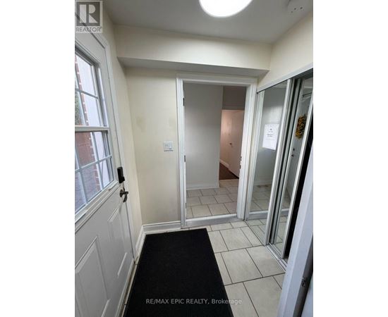 A hallway with a black mat on the floor.