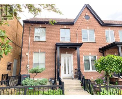 A red brick house with a black front door and steps leading up to it.