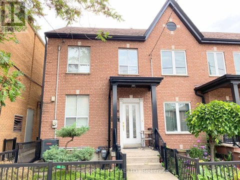 A red brick house with a black front door and steps leading up to it.