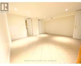 A spacious room with white walls and tile flooring is available for rent.