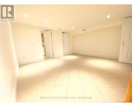 A spacious room with white walls and tile flooring is available for rent.