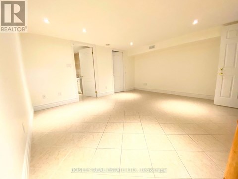 A spacious room with white walls and tile flooring is available for rent.